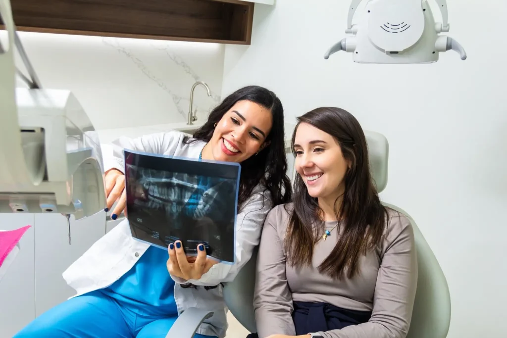 Dentist explaining a patient's dental X-ray during a consultation in a modern dental clinic, helping create a personalized treatment plan.