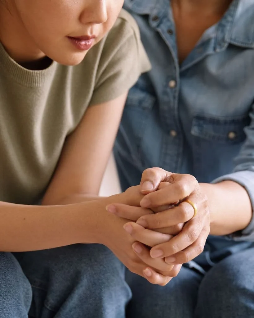 Person offering comfort and emotional support by holding another person's hands, representing compassionate dental care, patient reassurance, and anxiety support